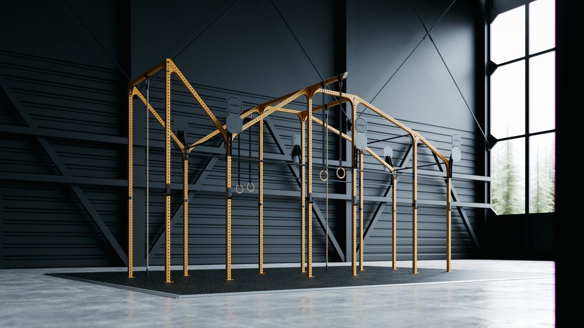Rig de entrenamiento amarillo con argollas y cuerdas junto a un ventanal