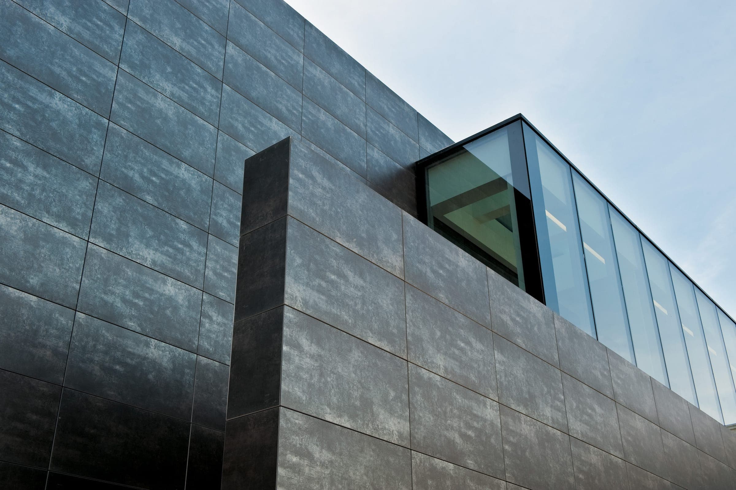 Fachada ventilada de placas de porcelanato gris oscuro vista desde abajo