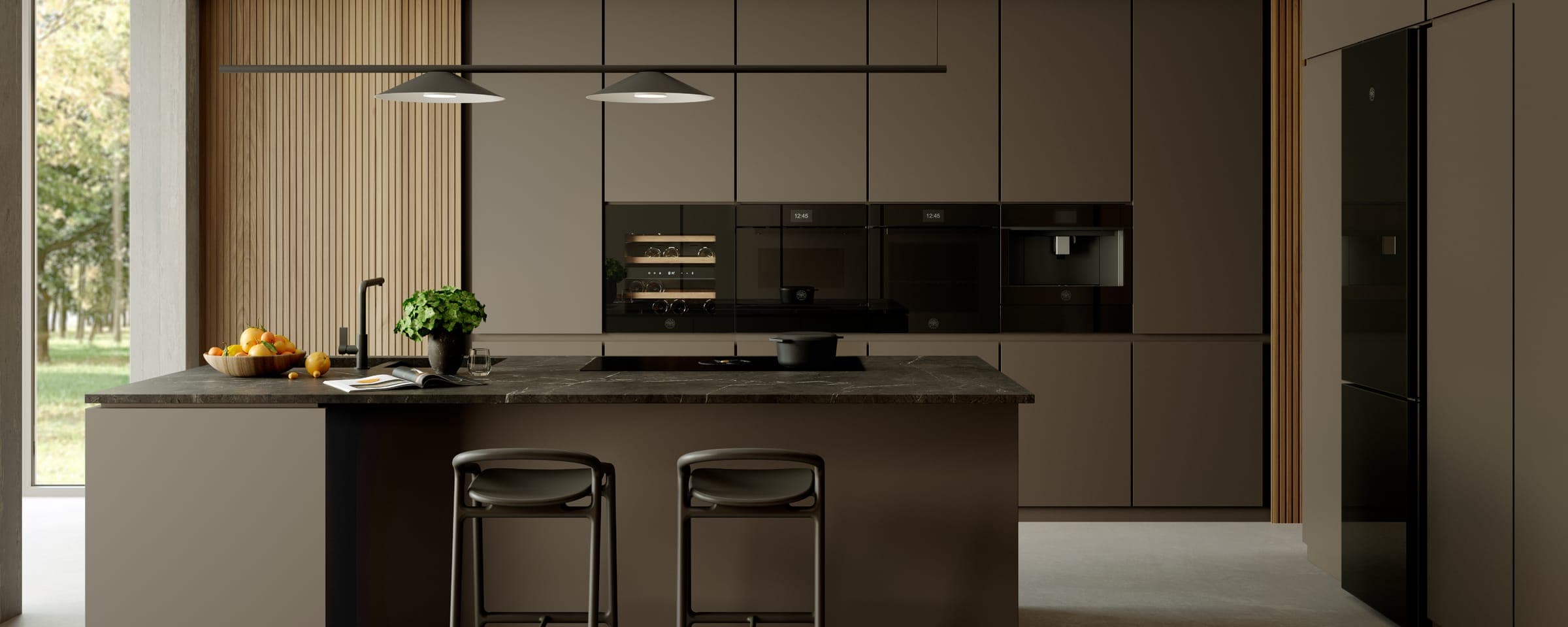 Cocina oscura con hornos en columna e isla