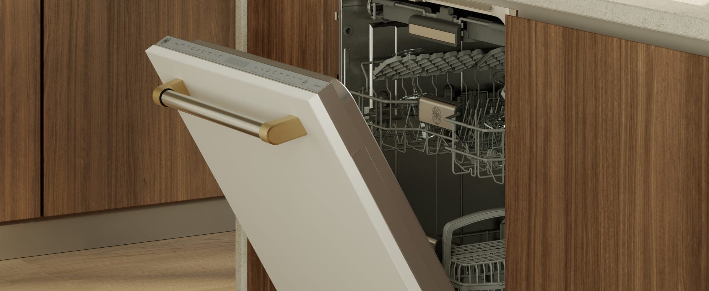 Lavavajillas entreabierto con panel frontal blanco y jaladera de acero con remates dorados, integrado entre muebles de madera; dentro se ven las canastillas con copas.