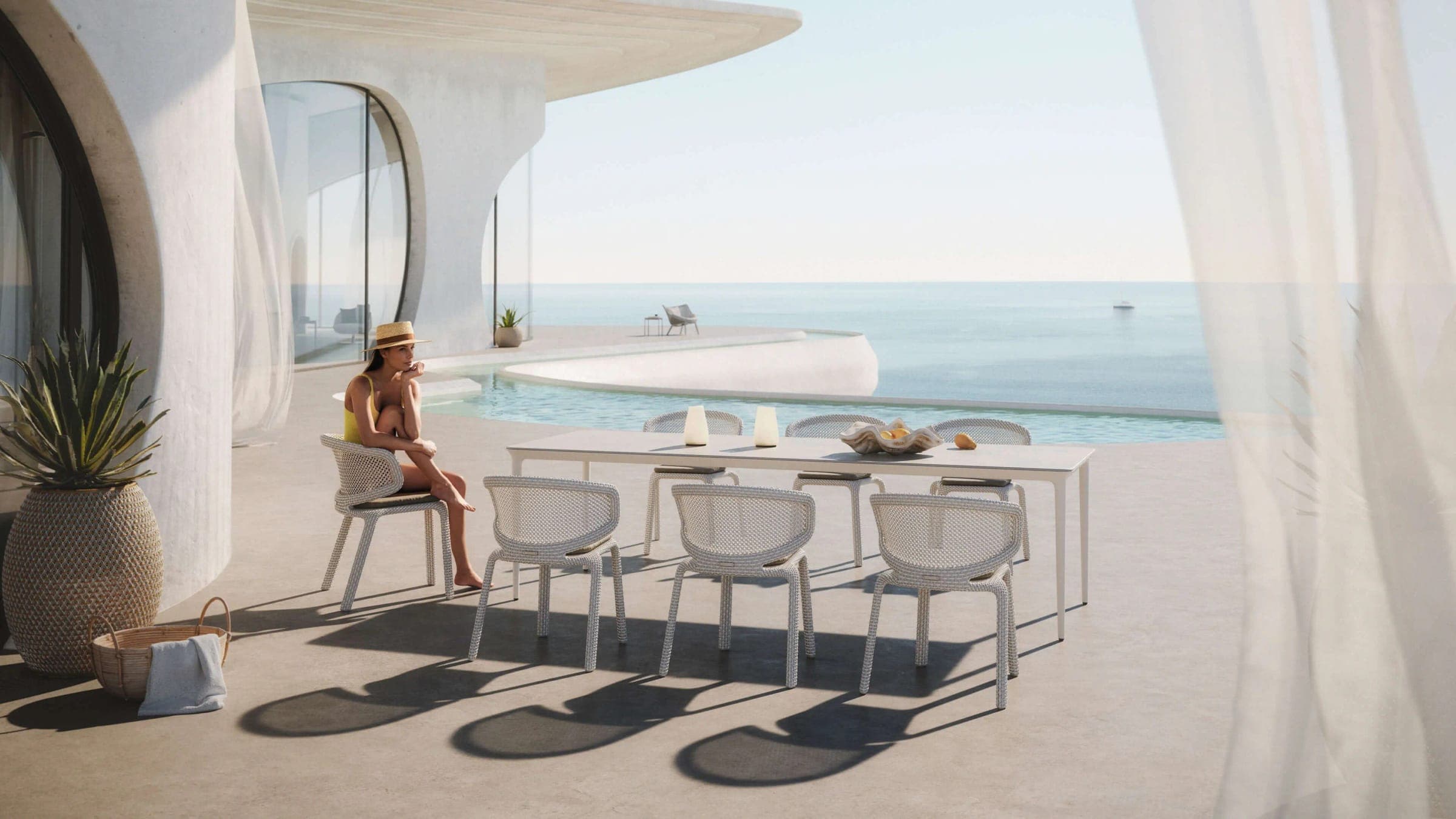 Comedor exterior blanco en una terraza frente al mar