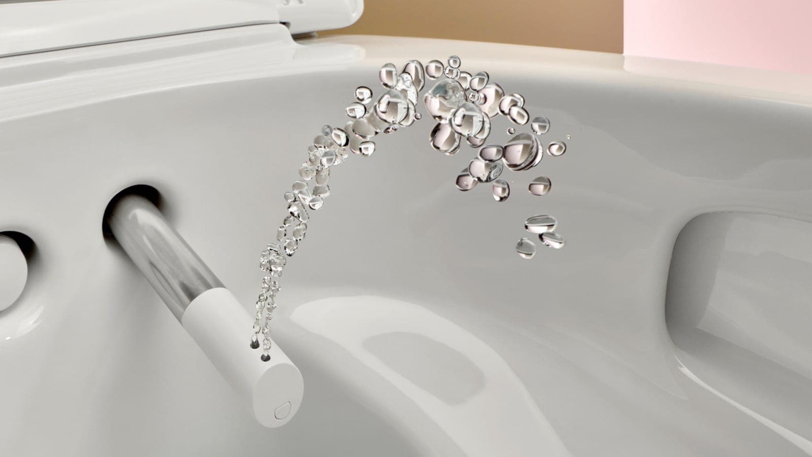 Acercamiento al interior de una taza de cerámica blanca: del brazo de ducha extendido, blanco y cromado, sale un arco de gotas de agua.