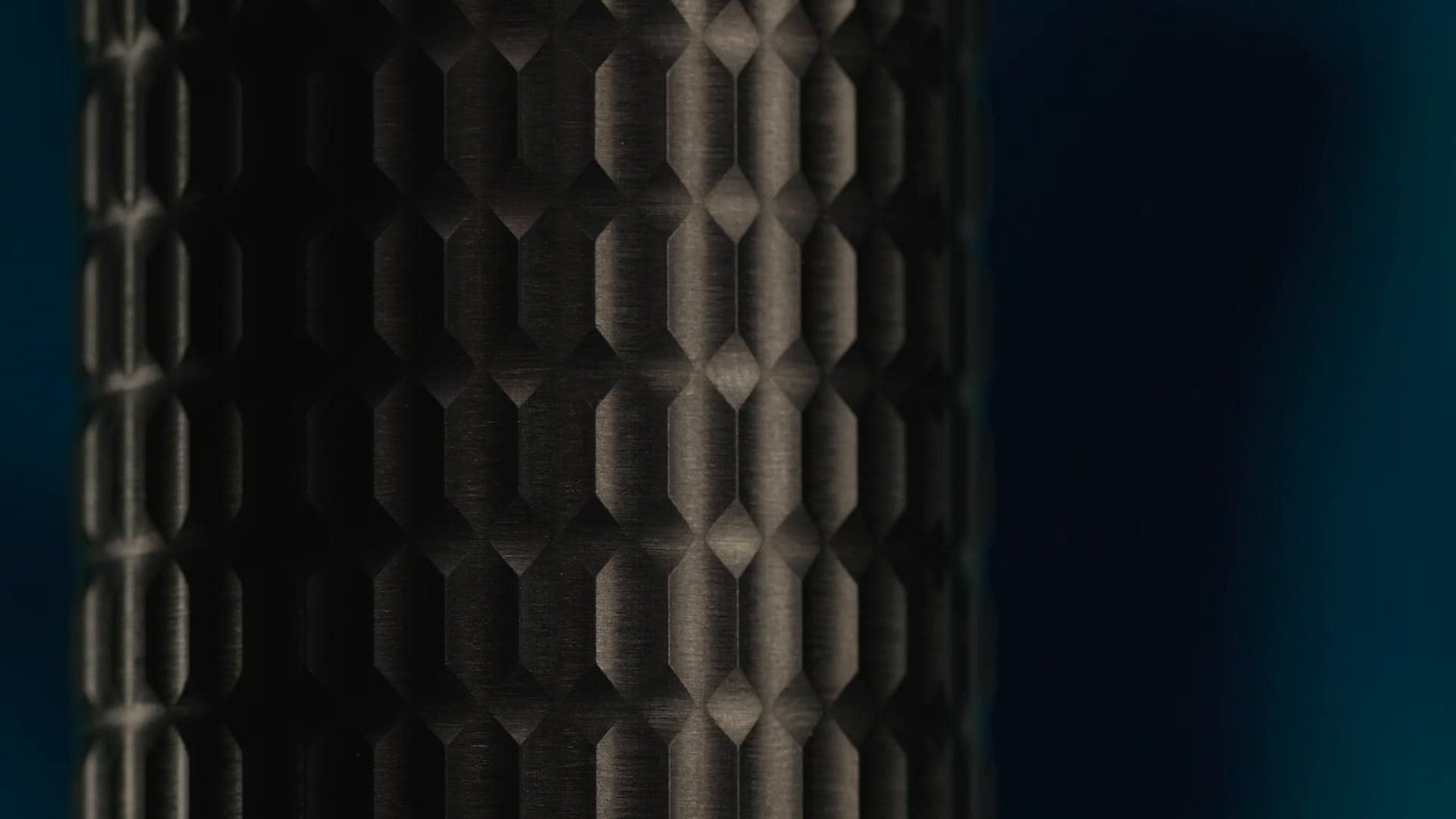 Textura en relieve de hexágonos alargados en un mezclador Gessi316 oscuro