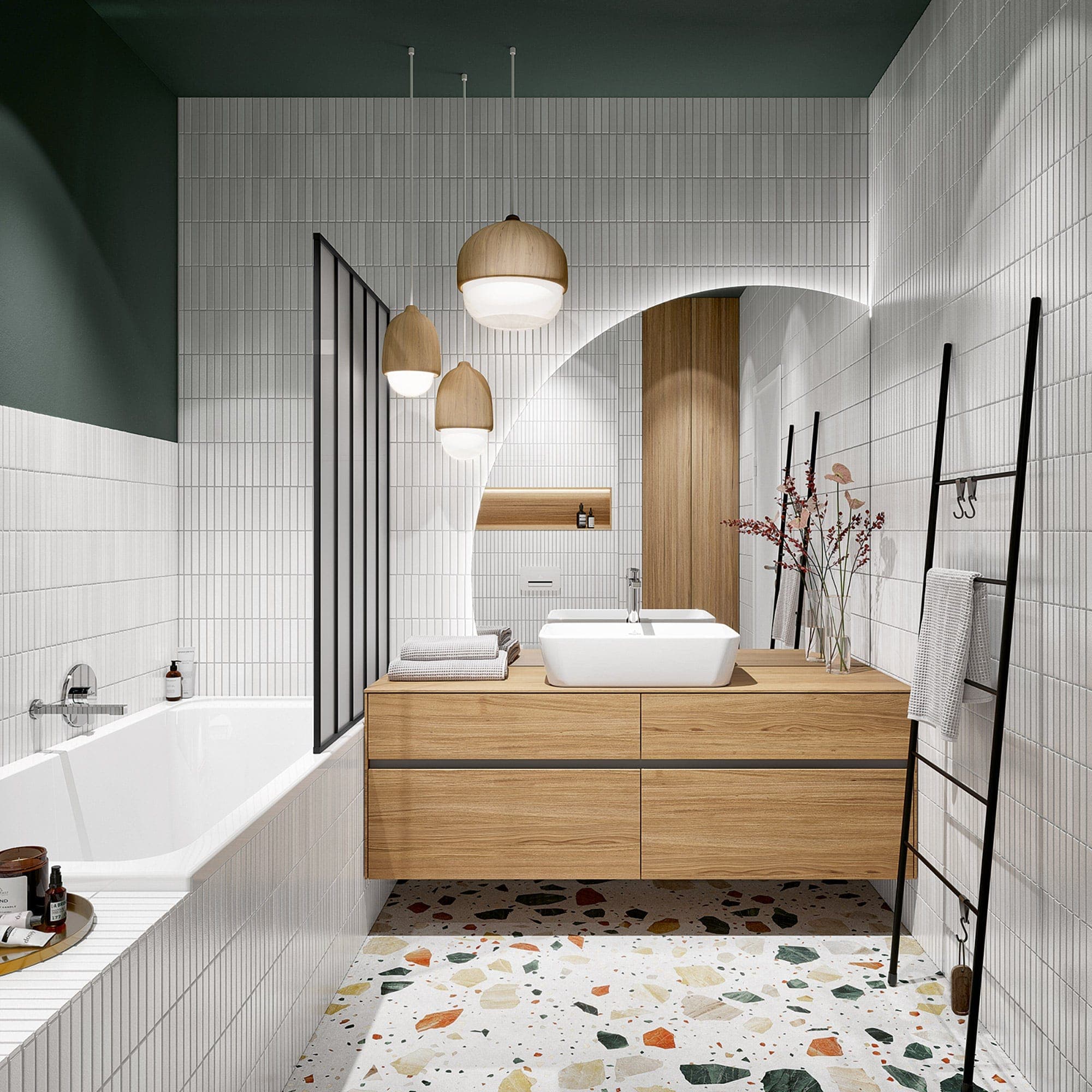 Baño con muros de azulejo blanco, parte superior verde oscuro y piso de terrazo: tina empotrada con grifería de pared cromada y un cancel de vidrio de perfil negro, lavabo rectangular sobre mueble de madera, lámparas colgantes, espejo de arco iluminado y toallero de escalera.