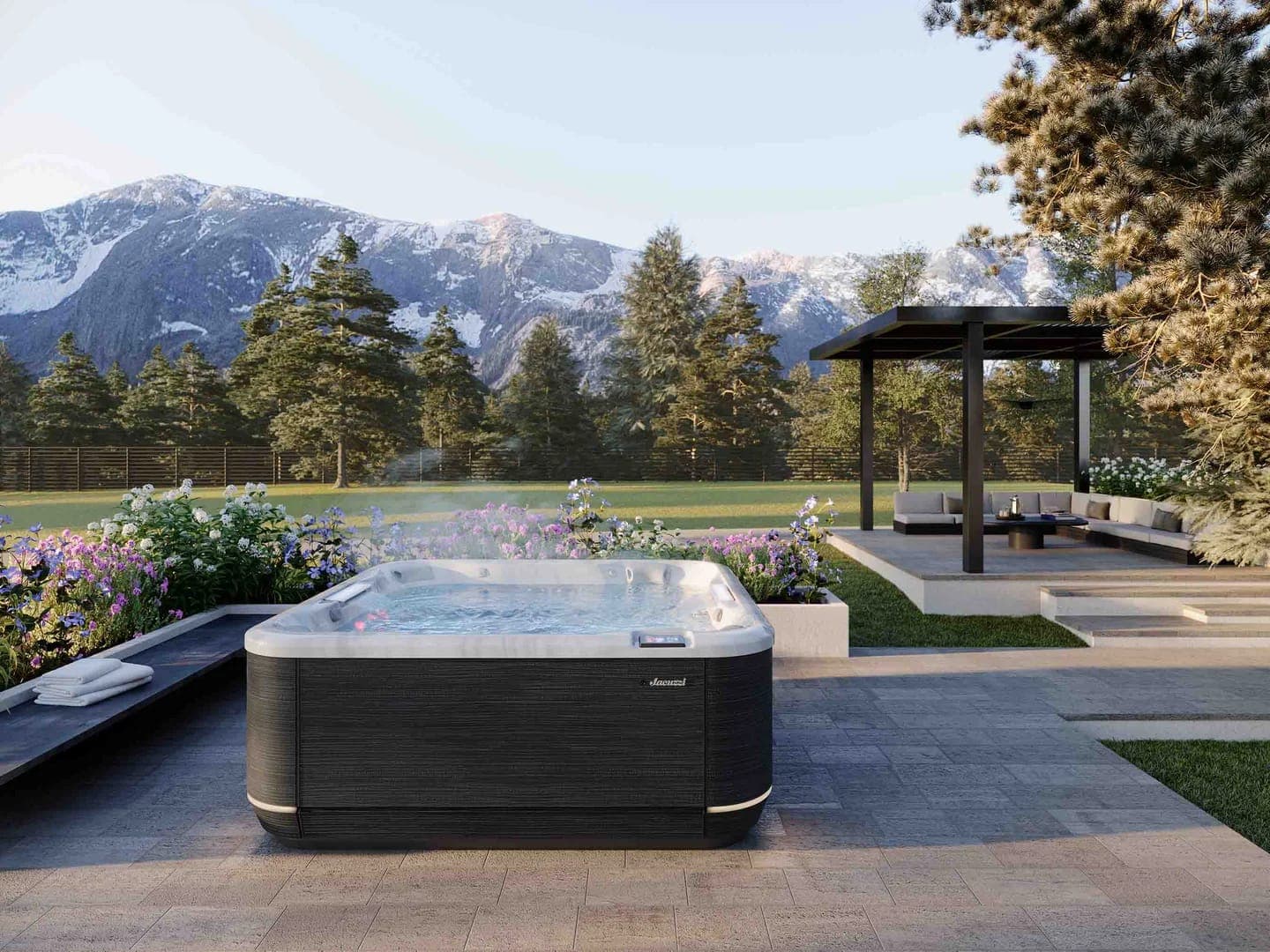 Spa de hidromasaje en un jardín con montañas nevadas al fondo