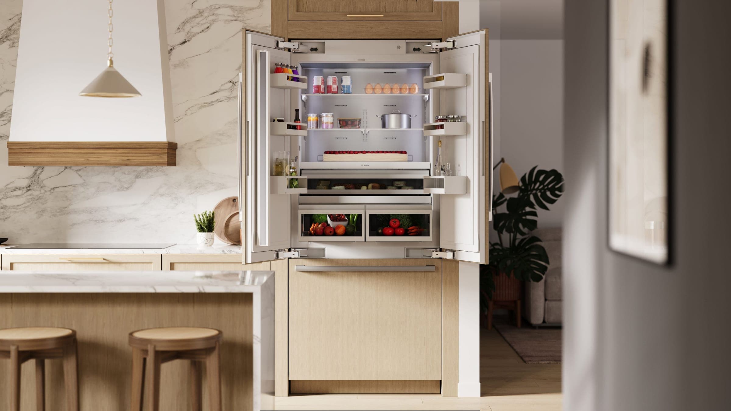 Refrigerador empotrado con paneles de madera clara y las puertas abiertas, junto a una isla de mármol