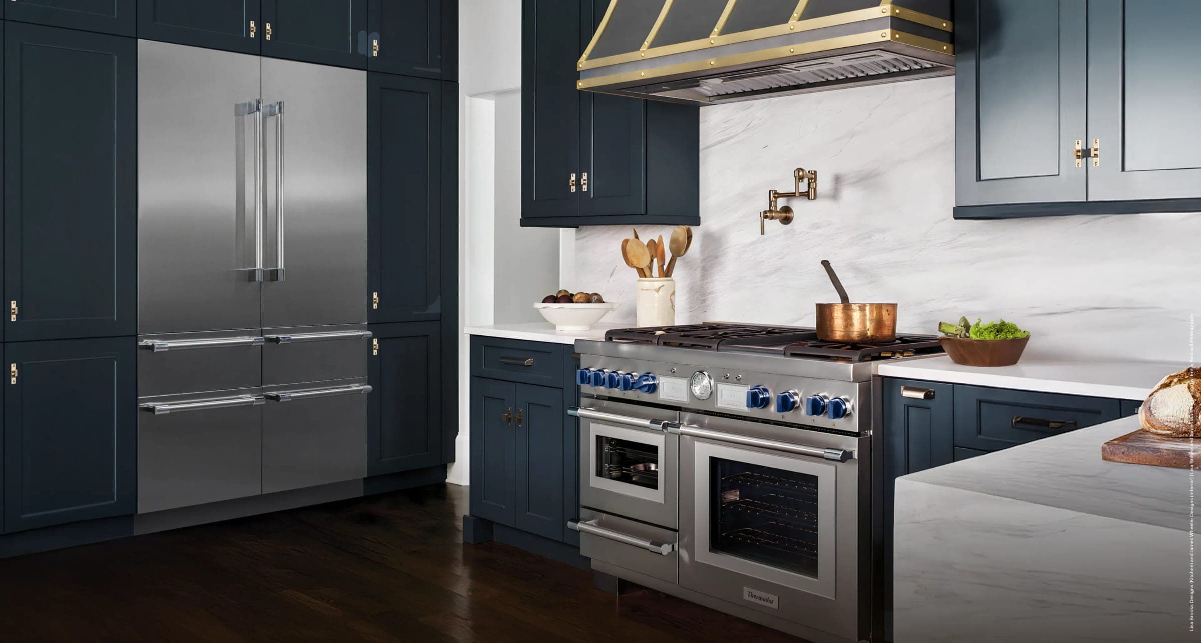 Cocina azul con refrigerador de acero y estufa profesional